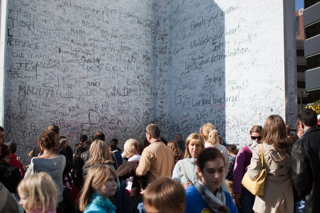 A crowd gathers beneath a giant greeting-card installation covered in handwritten signatures during ArtPrize in downtown Grand Rapids