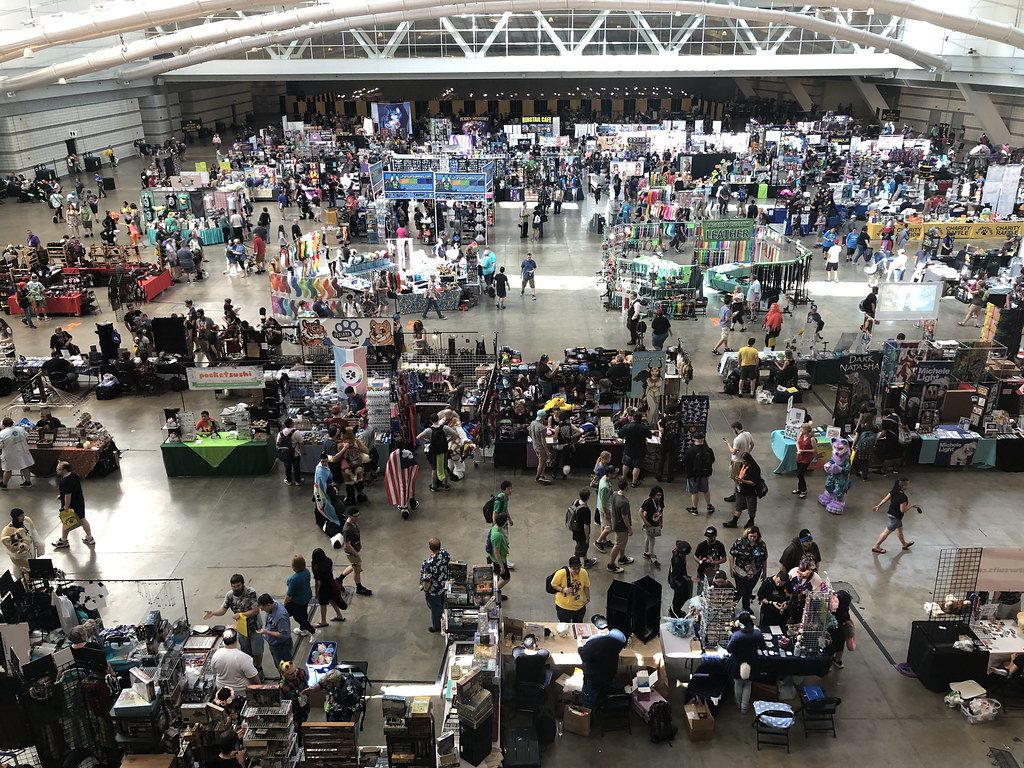 Overhead view of a packed Anthrocon dealers room under the sloped steel roof of the David L. Lawrence Convention Center