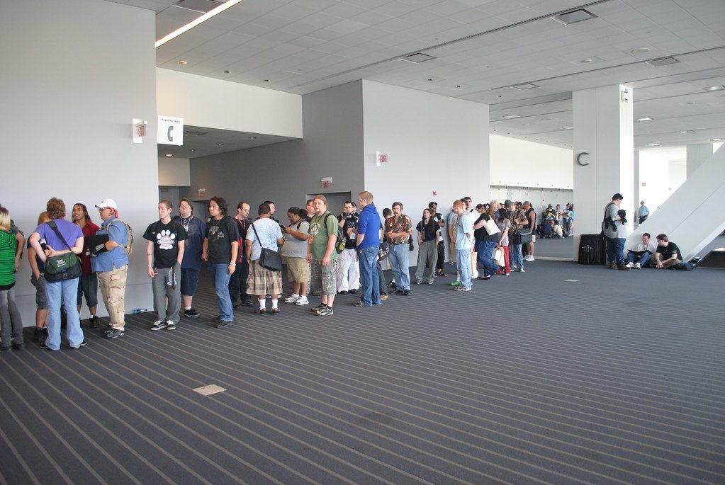 Anthrocon attendees queuing on the carpeted concourse outside Hall C of the David L. Lawrence Convention Center