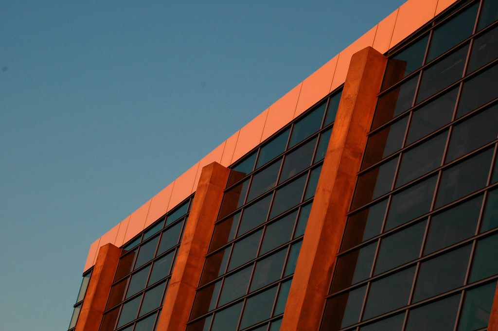 Low evening sun lighting the concrete piers and dark glass of a Georgia World Congress Center facade