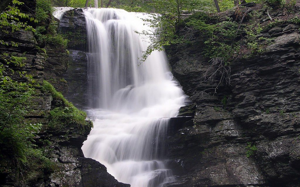 Fulmer Falls pouring over dark rock ledges between green trees in the Childs Recreation Area, Pocono Mountains