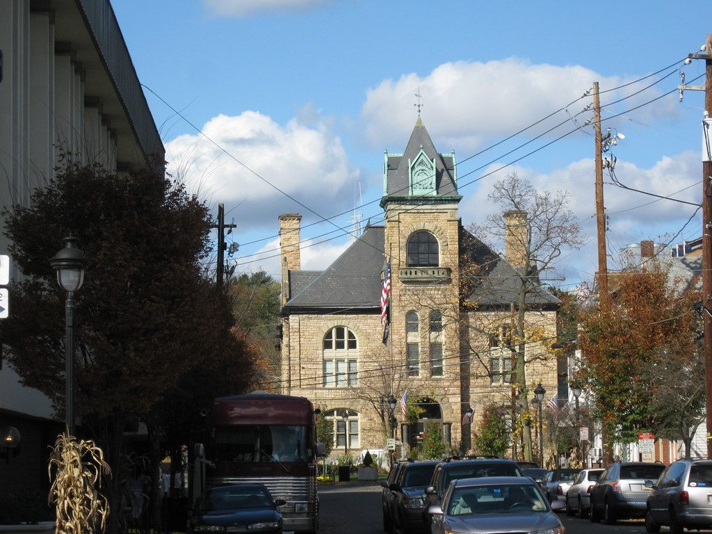 The stone Monroe County Courthouse with its copper-roofed tower at the end of a downtown Stroudsburg street