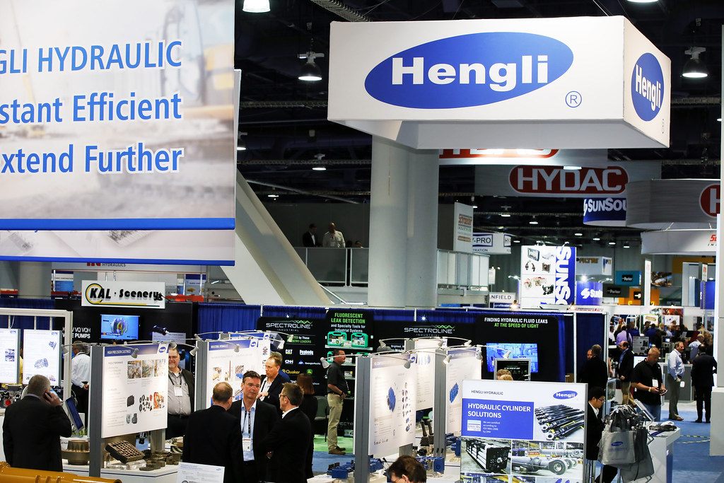 Exhibitors and visitors talking among hydraulics booths under a hanging Hengli sign at IFPE 2017 in the Las Vegas Convention Center