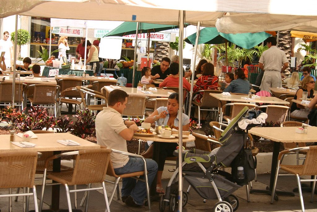 People eat brunch at shaded cafe tables along Lincoln Road in Miami Beach
