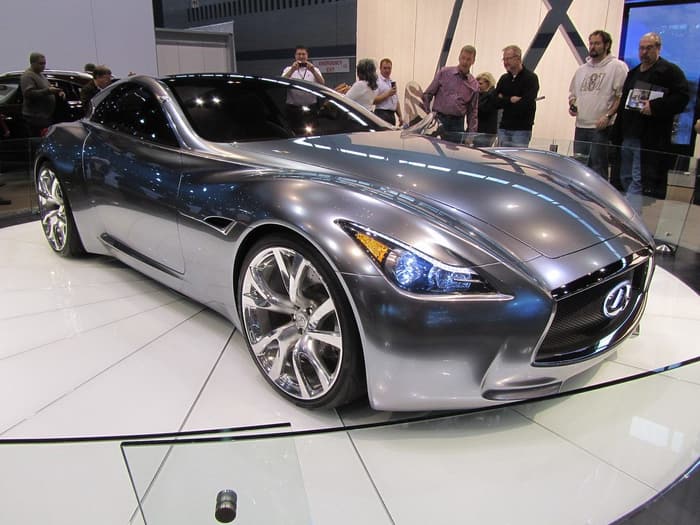 Visitors photographing a silver Infiniti concept coupe on a white turntable at the 2011 Chicago Auto Show