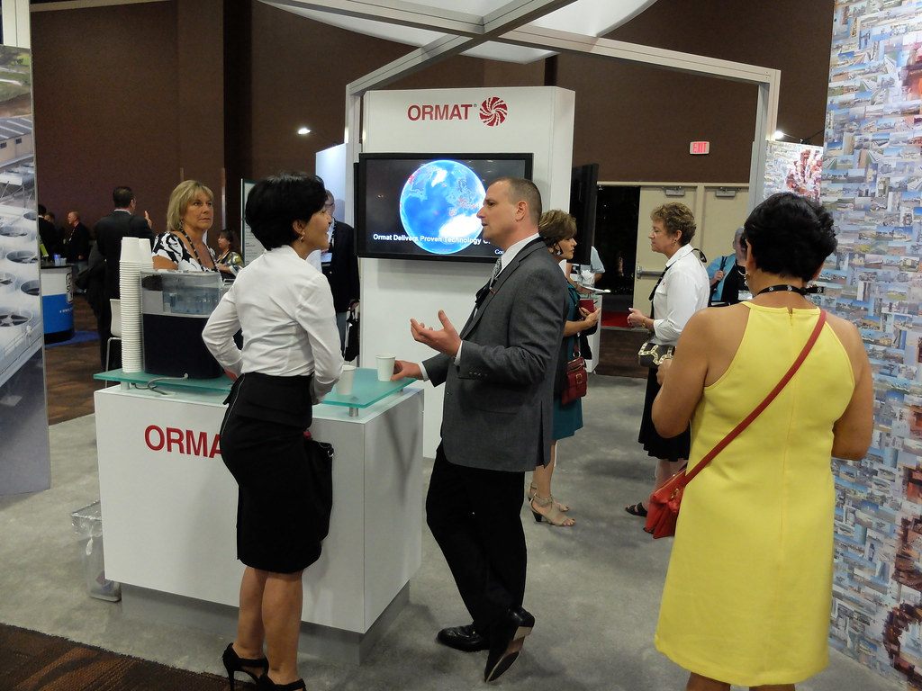 An exhibitor talks with attendees at the Ormat booth during the GEA Geothermal Expo 2013 in Las Vegas