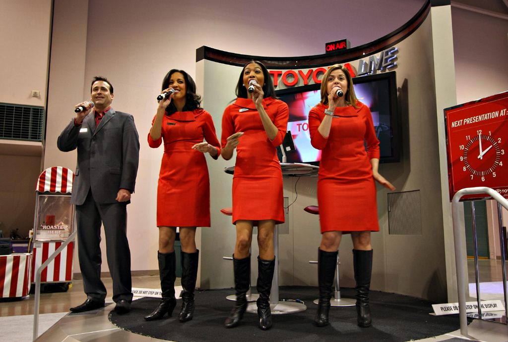Singers in matching red dresses performing a live stage show at the Toyota exhibit, 2010 Twin Cities Auto Show