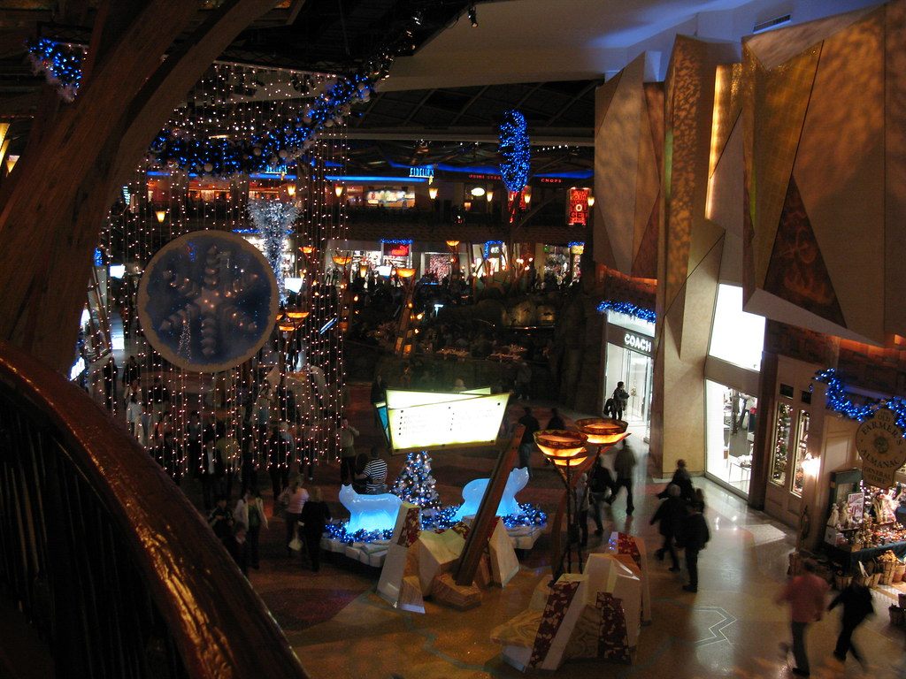 Visitors stroll past holiday lights, a glowing fountain display and shopfronts in the Mohegan Sun concourse in Uncasville