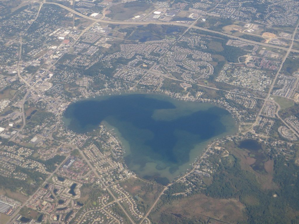 Aerial view of Novi, Michigan: subdivisions, a freeway and a large lake surrounded by houses