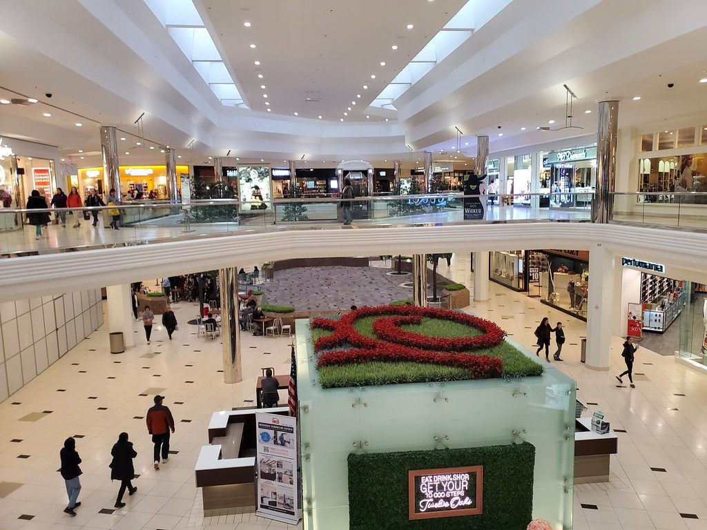 The two-level atrium of Twelve Oaks Mall in Novi, with a planted centre display and shoppers on both floors