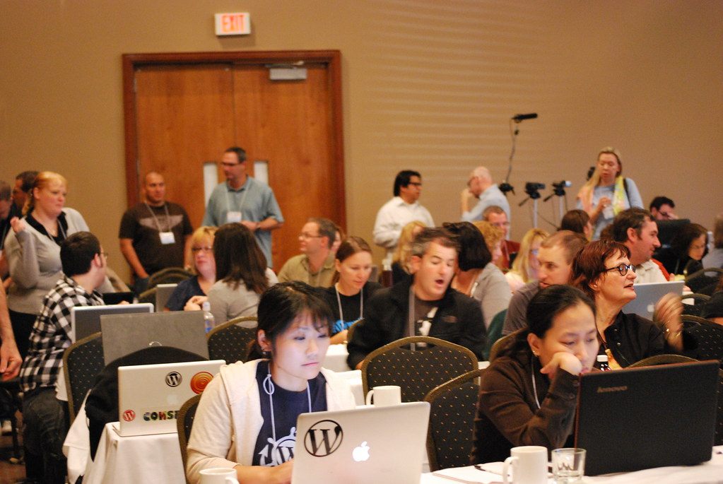 A full session room of attendees with laptops at draped tables during WordCamp Detroit 2010 at the Novi showplace, then named Rock Financial Showplace