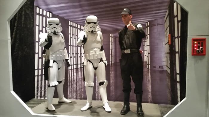 Two stormtrooper costumers and an Imperial officer posing in a Death Star corridor photo set at Star Wars Celebration Orlando 2017 in the Orange County Convention Center