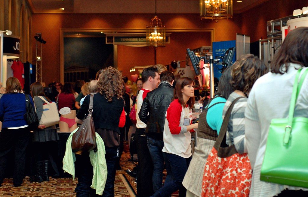 Attendees browse sponsor booths in a chandeliered Opryland foyer during the Blissdom 2011 conference