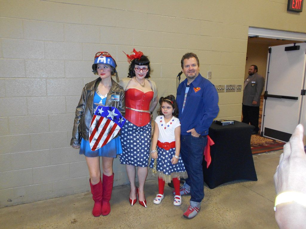 Costumed fans in Captain America and Wonder Woman outfits pose at a comic convention at Opryland