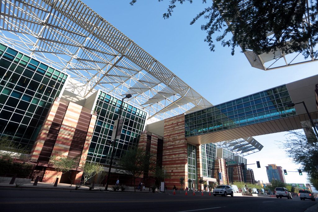 The Phoenix Convention Center's glass and sandstone-colored facade under its huge steel shade canopy, with the skybridge over the street