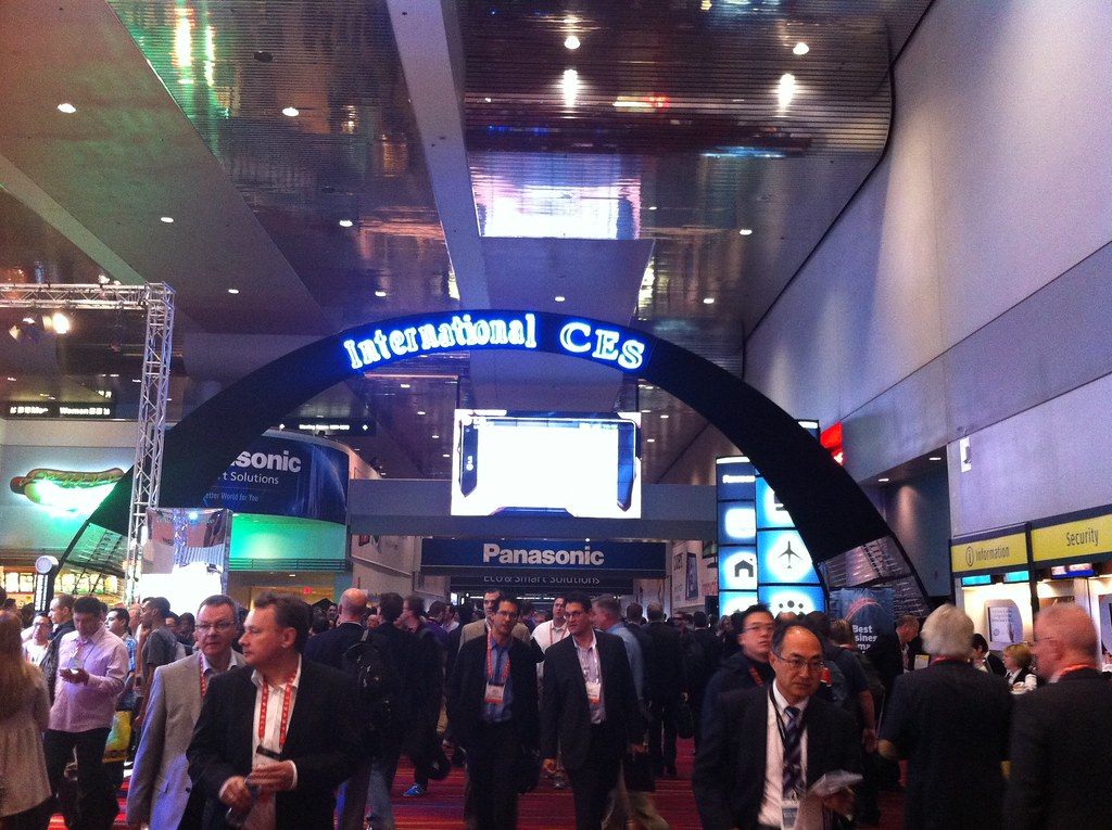 Badge-wearing attendees walk under the International CES arch inside the Las Vegas Convention Center