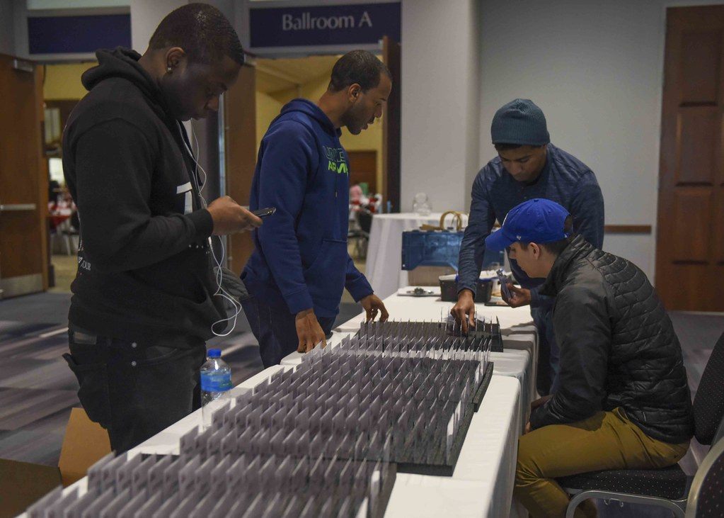 Volunteers sort rows of name badges on a long table outside Ballroom A at the Rhode Island Convention Center before an American Heart Association event