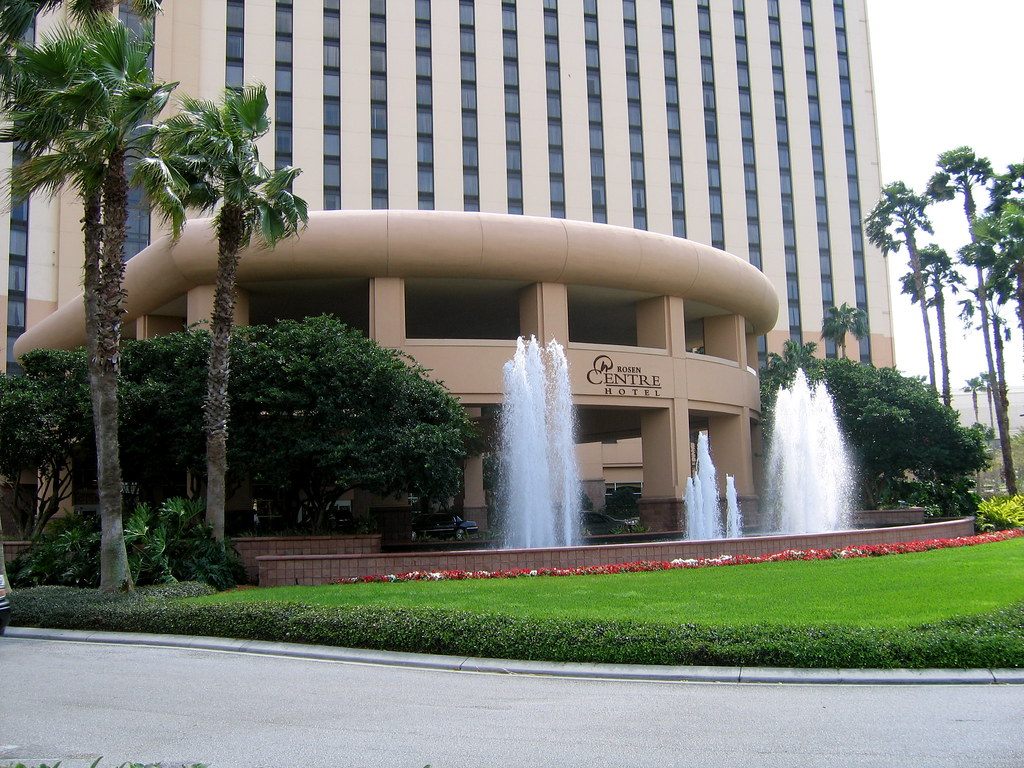 Fountains in front of the round, colonnaded Rosen Centre Hotel entrance drive, framed by palm trees, with the hotel tower above