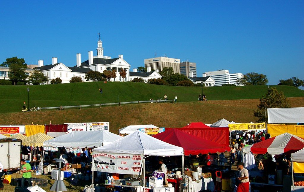 Food-vendor tents along the riverfront festival grounds, below the white Ethyl Corporation headquarters on the hill and downtown office towers