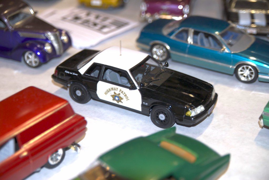 A model California Highway Patrol Mustang among other scale model cars on a contest table at a Santa Clara model car show