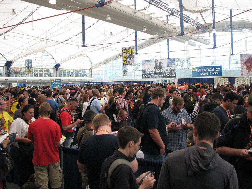 A dense Comic-Con crowd under the white fabric roof of the Sails Pavilion, with a Ballroom 20 sign and show banners along the far wall