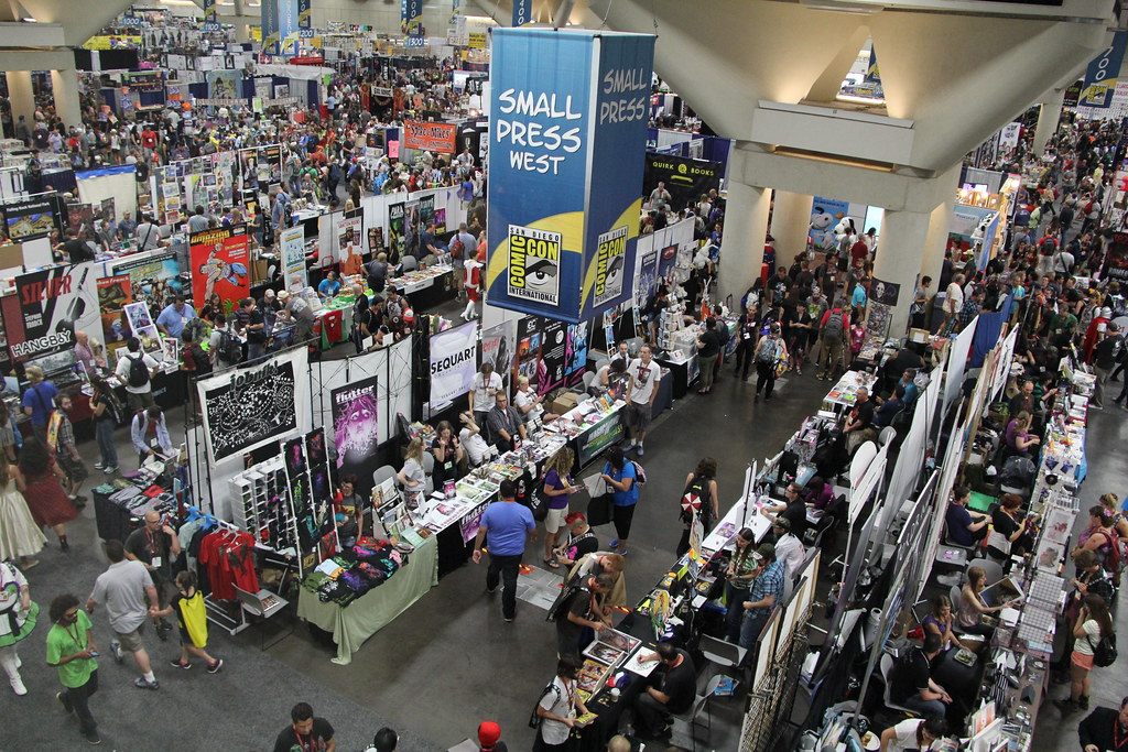 Overhead view of the crowded Small Press area at Comic-Con 2014 in the San Diego Convention Center, with rows of tables under a Small Press West banner