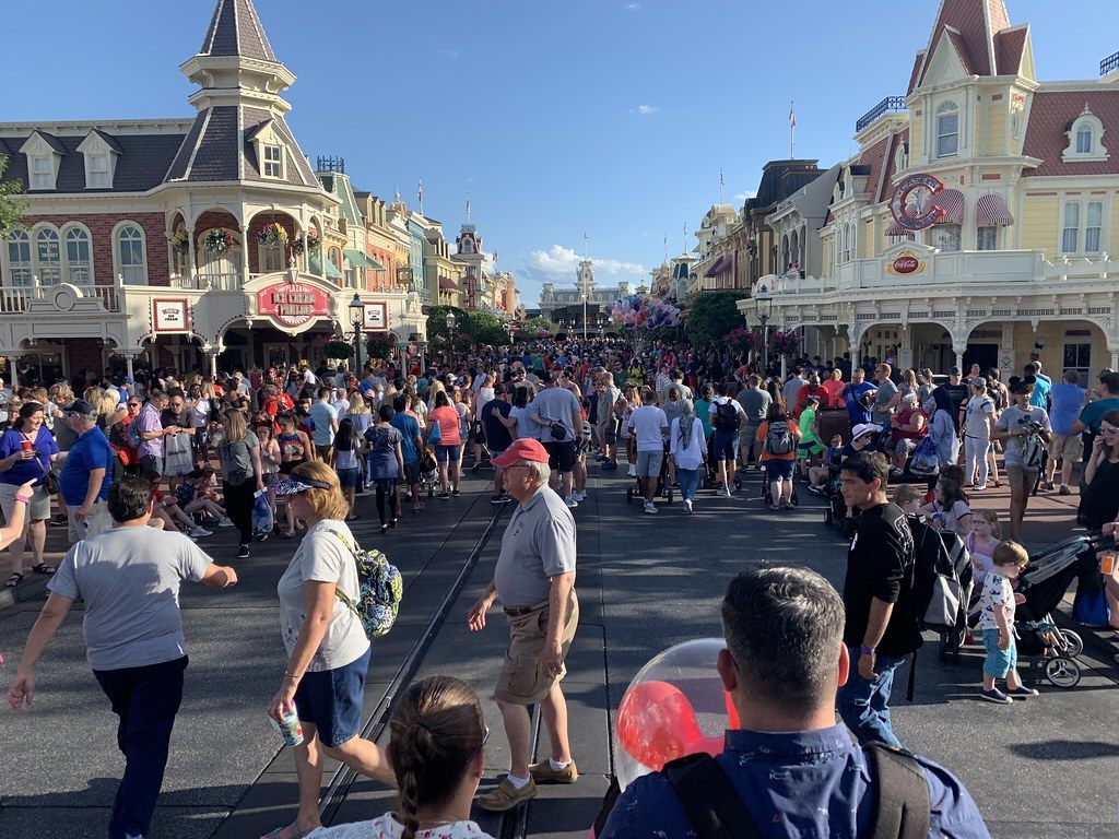 Main Street, U.S.A. at Magic Kingdom packed with spring-break crowds under a blue sky