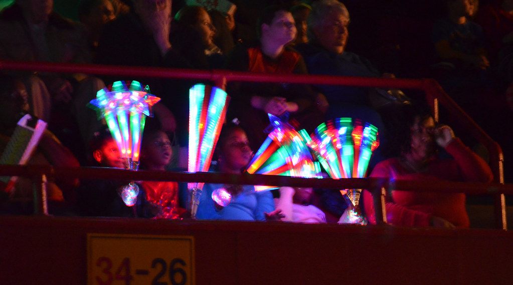 Children in arena seating wave glowing light-up wands during the Royal Hanneford Circus in Westchester, NY, February 2013