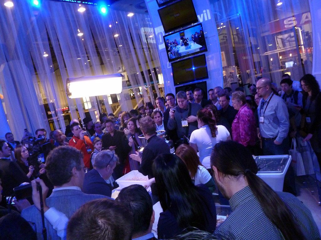 A crowd with cameras and phones packs the NBC Universal booth during CES 2011 in Las Vegas