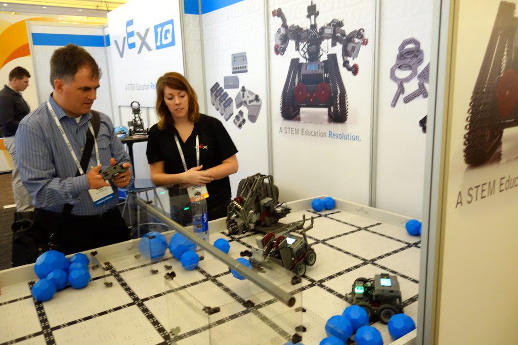 An attendee tries a VEX IQ robot as an exhibitor looks on at CES 2014 in Las Vegas