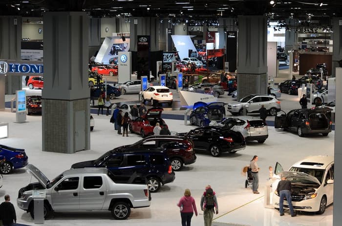 The 2014 Washington Auto Show floor seen from above, with rows of new cars, brand signs and visitors among the hall columns