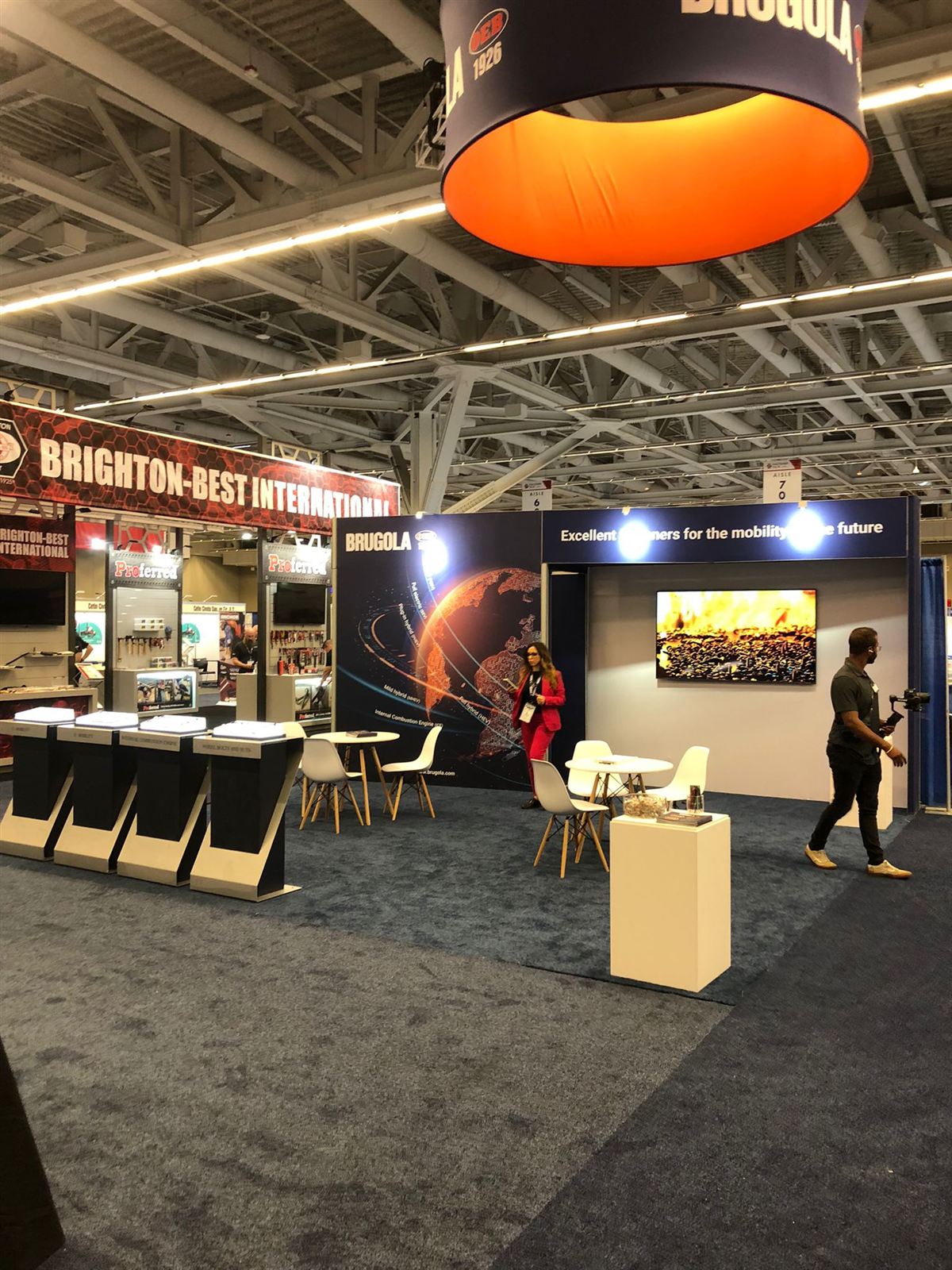 Brugola OEB island booth with glowing globe graphic and lit product pedestals at Fastener Fair USA