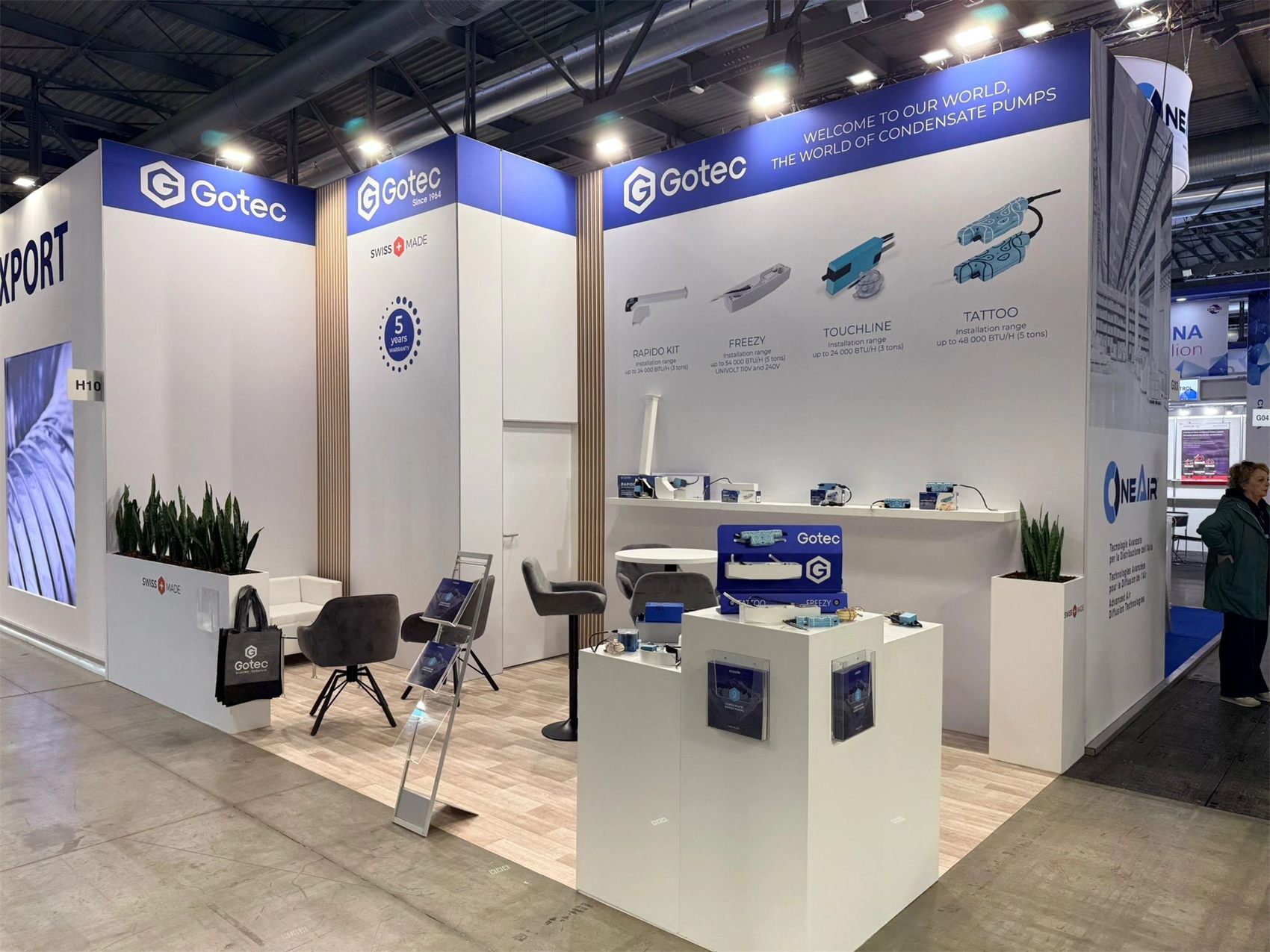 Design render of a 10×20 corner trade show booth: corner booth with tall graphic walls and product pedestals