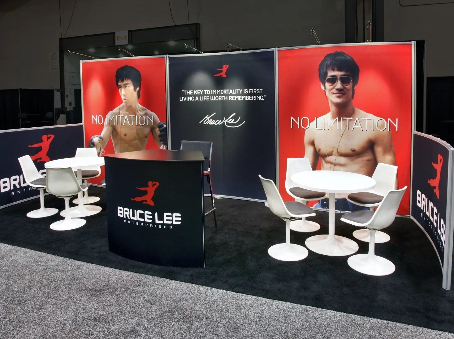 Design render of a 10×20 inline trade show booth: inline booth with large portrait graphics and two meeting tables