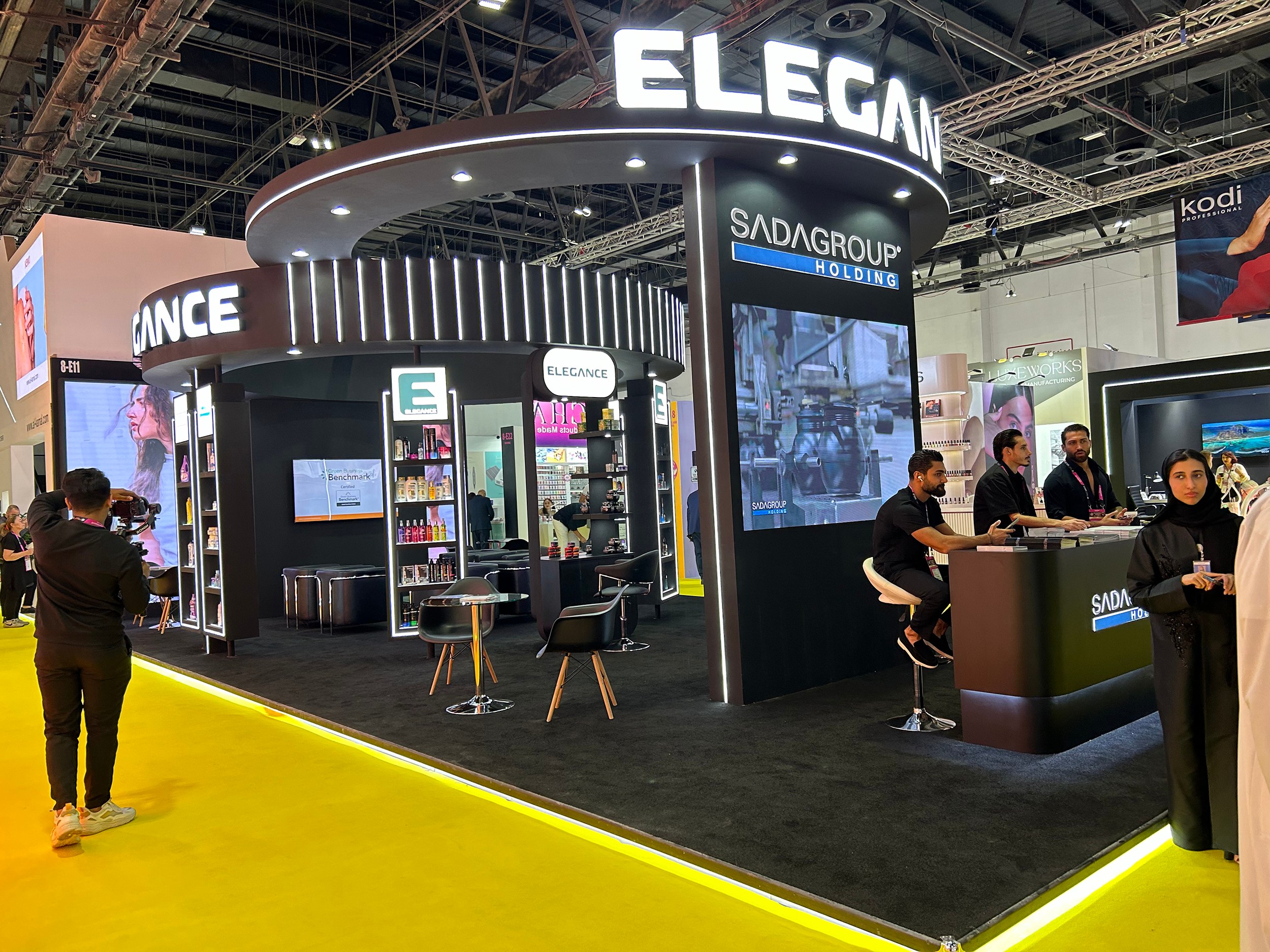 Design render of a 20×30 corner trade show booth: corner booth with ring canopy and video screens