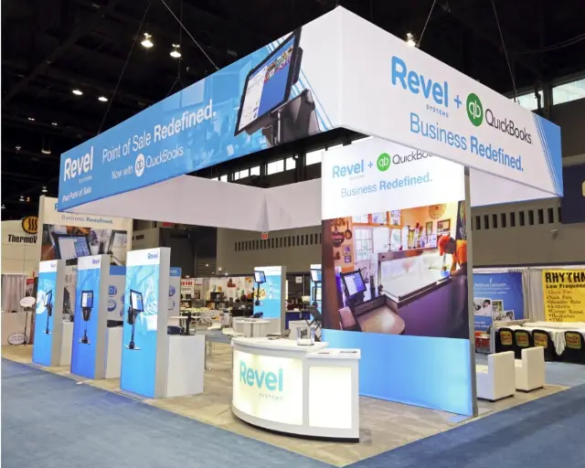 20×30 Island Booth With Rectangular Overhead Frame and Backlit Kiosk Towers