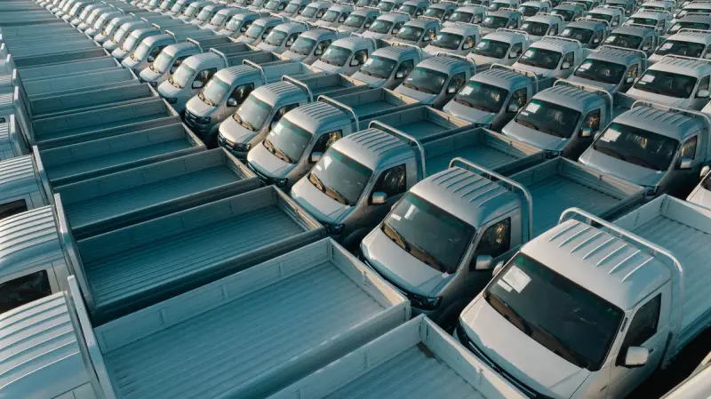 Aerial view of rows of new silver pickup trucks parked in neat lines