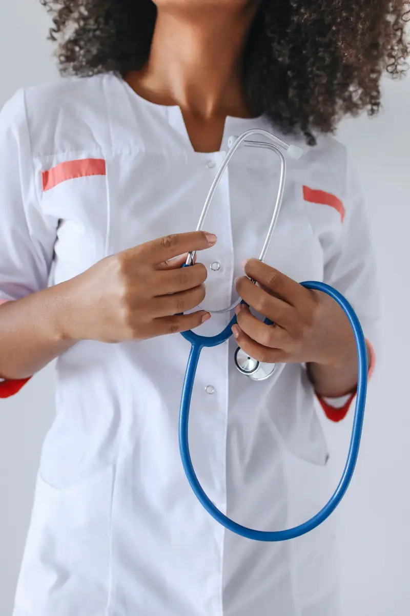 Close view of a healthcare worker’s hands holding a stethoscope