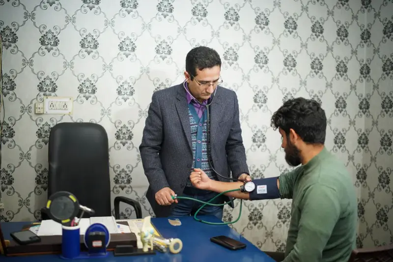 Clinician measuring a patient’s blood pressure during an indoor consultation
