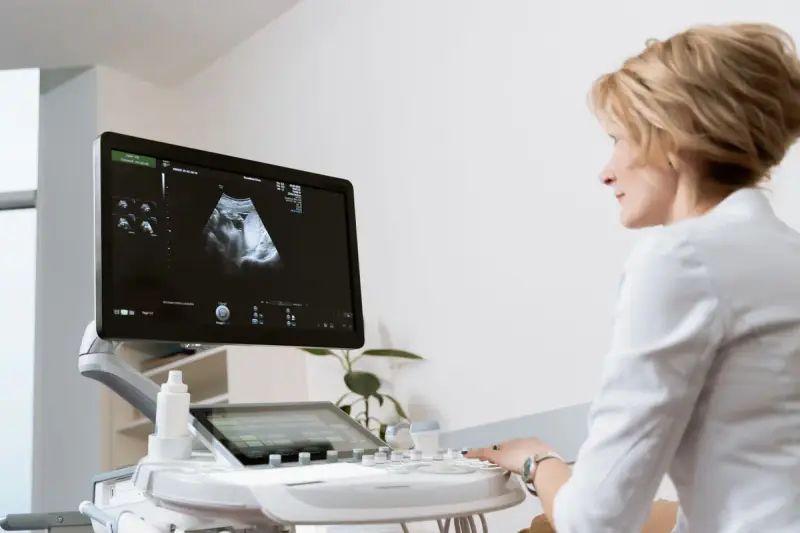 Female doctor using an ultrasound scanner in a modern medical clinic