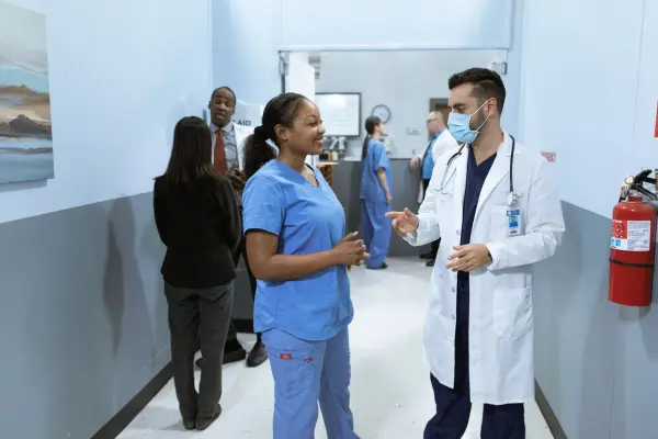 Medical professionals discussing work in a hospital hallway