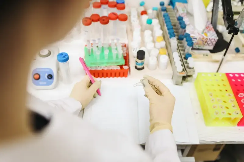 Scientist analyzing samples among test tubes and lab equipment