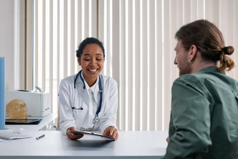Doctor and participant smiling during a consultation in a bright clinic