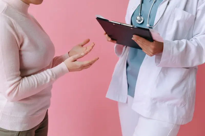 Participant speaking with a doctor who holds a clipboard