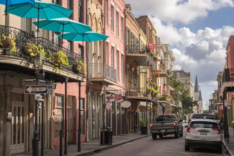 Colorful French Quarter street in New Orleans with iron balconies and umbrellas