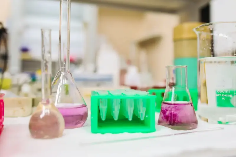Beakers and flasks holding colored solutions on a chemistry bench