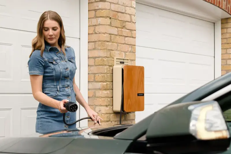 Woman connecting a home charging cable to an electric car