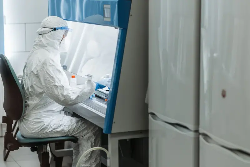 Scientist working with laboratory equipment in a controlled clean environment