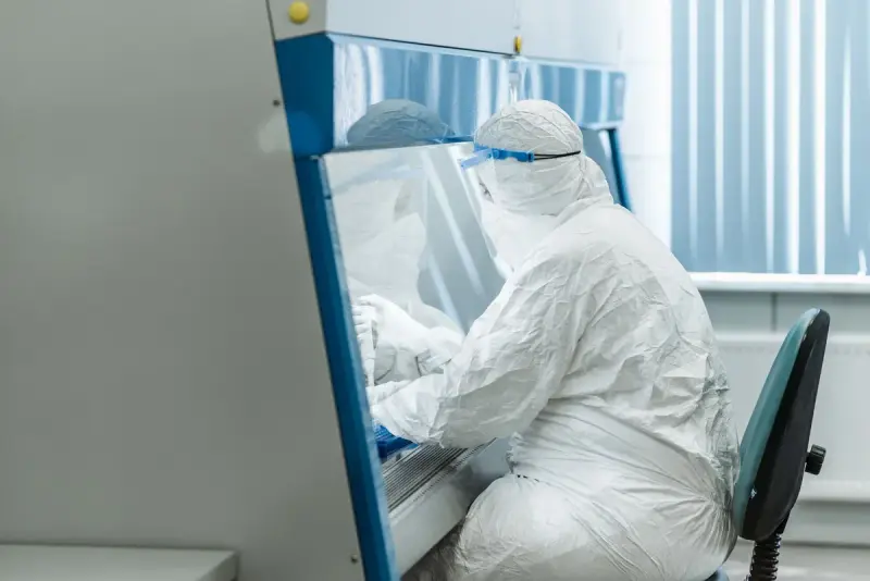 Researcher in full protective equipment working in a laboratory