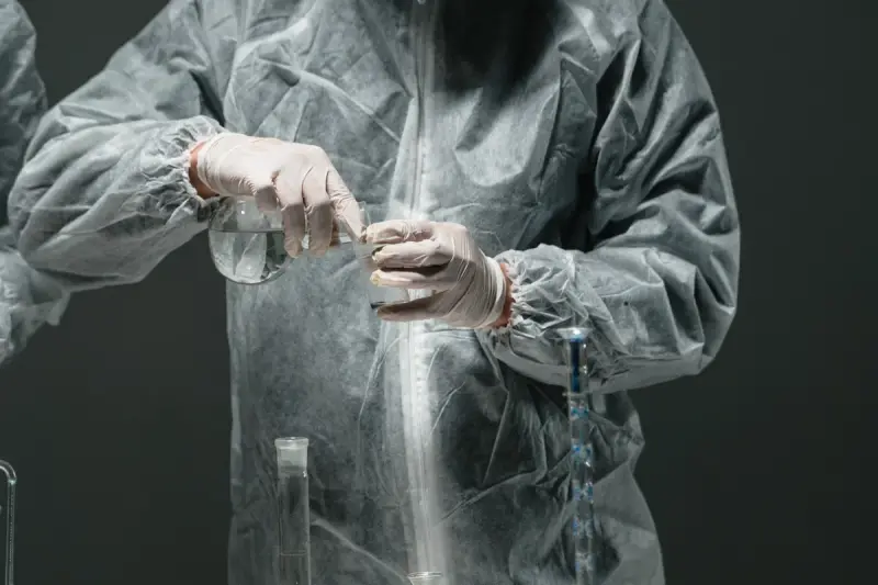 Scientist in protective equipment holding a flask during an experiment